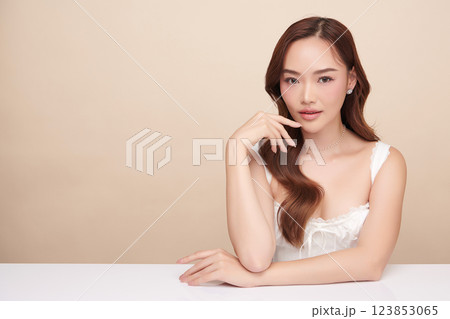 A beautiful young Asian woman with clean, fresh skin against a beige background. She represents beauty, skincare, and spa treatments. A beautiful young Asian woman with clean, fresh skin against a beige background. She represents beauty, skincare, and spa treatments. 123853065