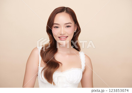 A beautiful young Asian woman with clean, fresh skin against a beige background. She represents beauty, skincare, and spa treatments. A beautiful young Asian woman with clean, fresh skin against a beige background. She represents beauty, skincare, and spa treatments. 123853074