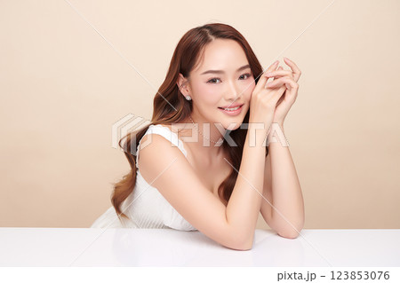 A beautiful young Asian woman with clean, fresh skin against a beige background. She represents beauty, skincare, and spa treatments. A beautiful young Asian woman with clean, fresh skin against a beige background. She represents beauty, skincare, and spa treatments. 123853076