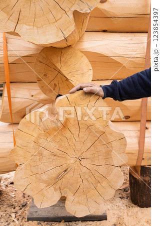 The construction site of a wooden house. Traditional log cabin built from wood logs on sunny summer day. Cottage house design The construction site of a wooden house. Traditional log cabin built from wood logs on sunny summer day. Cottage house design 123854397