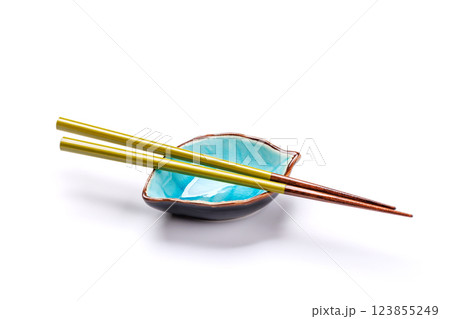 A sushi chopsticks and a small bowls, elegantly arranged on a clean white background A sushi chopsticks and a small bowls, elegantly arranged on a clean white background 123855249