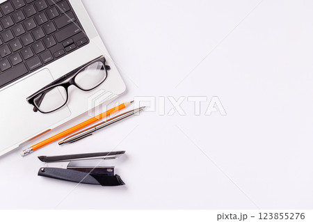 A desk featuring a laptop and office supplies 123855276