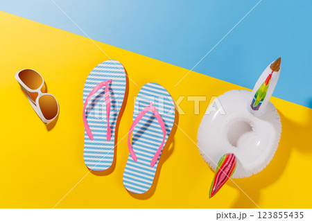A vibrant summer vacation scene with flip flops, shades, and a floating flamingo 123855435