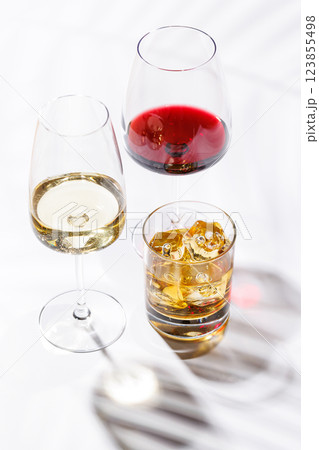 A refined composition of wine glasses filled with red and white wine, paired with a whiskey glass 123855498