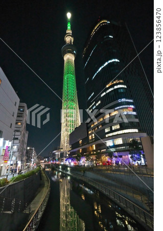 冬 東京ソラマチの北十間川から見上げるグリーンにライトアップされたスカイツリー 123856470