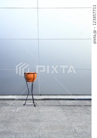 Retro style Clay pot Ashtray in front of wall made from light blue synthetic materials on modern building. 123857711