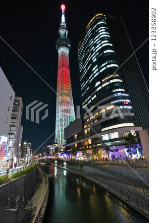 冬 東京ソラマチの北十間川から見上げる赤色にライトアップされたスカイツリー 123858902
