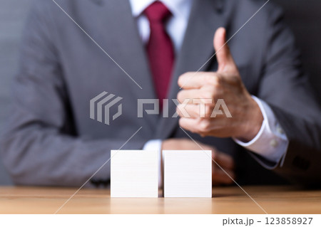 2つの白い木のブロックと親指を立てるミドル男性ビジネスマン 123858927