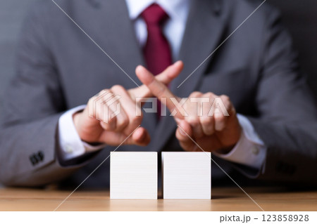 2つの白い木のブロックとバツサインをするミドル男性ビジネスマン 123858928