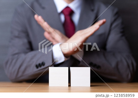 2つの白い木のブロックとバツサインをするミドル男性ビジネスマン 123858959