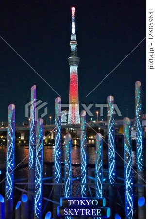 夜の青い隅田川イルミネーション越しにライトアップされた赤いスカイツリー夜景 123859631