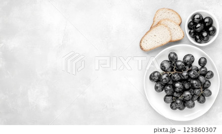 Black grapes with bread and olives on plate 123860307