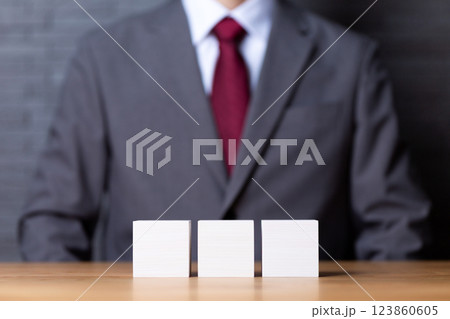 3つの白い木のブロックとスーツを着たミドル男性ビジネスマン 123860605