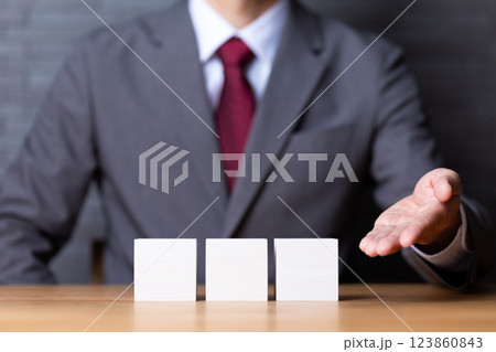 3つの白い木のブロックとスーツを着たミドル男性ビジネスマン 123860843