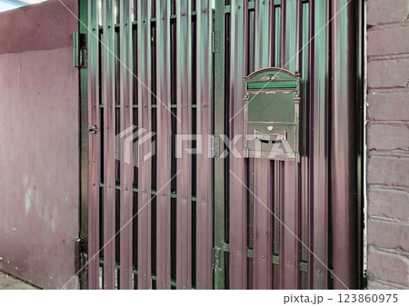 Modern mailbox on a new metal gate made of siding and profiles Modern mailbox on a new metal gate made of siding and profiles 123860975