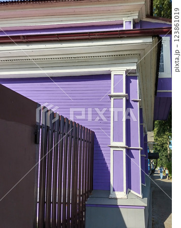 Corner of residential purple house with concrete foundation and metal siding fence Corner of residential purple house with concrete foundation and metal siding fence 123861019