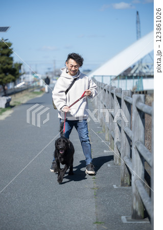 河川敷で大型犬の散歩を楽しむ男性 河川敷で大型犬の散歩を楽しむ男性 123861026