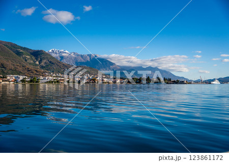Bay of Kotor in Montenegro and the top of high snow-capped mountains, small settlements on the coast and the bright blue waters of the Adriatic Sea. 123861172