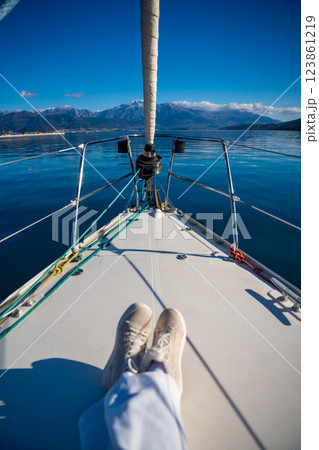 Feet of young woman on bow of the yacht during sailing in the morning in winter time in Adriatic sea, yacht life and yachting concept 123861219