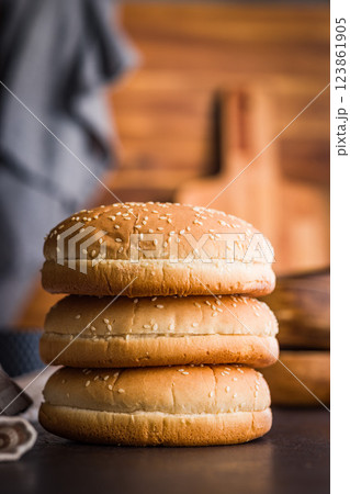 Empty burger bun with sesame seeds on black table. 123861905