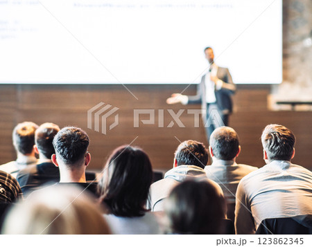 Speaker giving a talk in conference hall at business event. Rear view of unrecognizable people in audience at the conference hall. Business and entrepreneurship concept 123862345
