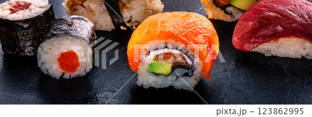Sushi rolls on a black background panorama. Uramaki with salmon Sushi rolls on a black background panorama. Uramaki with salmon 123862995