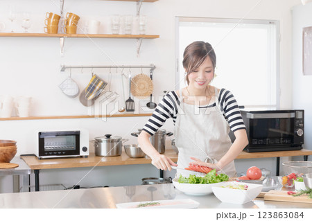 キッチンで料理をするエプロン姿の女性 123863084