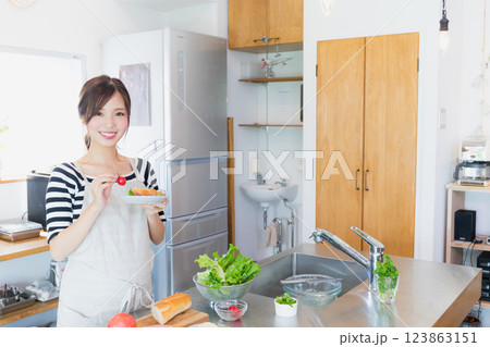 キッチンで料理をするエプロン姿の女性 123863151