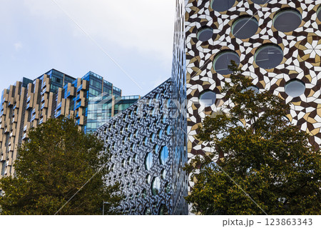 Modern architectural building with unique geometric facade and reflective windows Modern architectural building with unique geometric facade and reflective windows 123863343