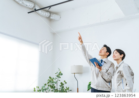 タブレットを見ながら建物を点検する作業員グループ 123863954