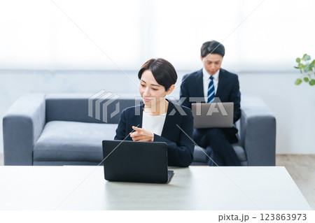 オフィスでノートパソコンを使って作業する男女ビジネスパーソンのグループ 123863973