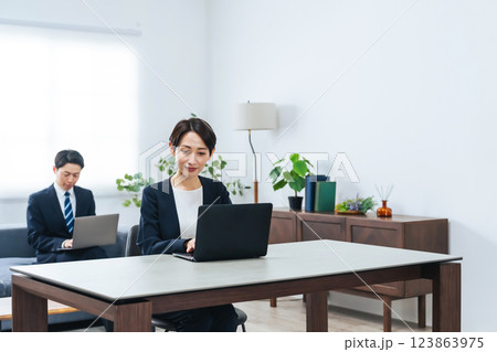 オフィスでノートパソコンを使って作業する男女ビジネスパーソンのグループ 123863975