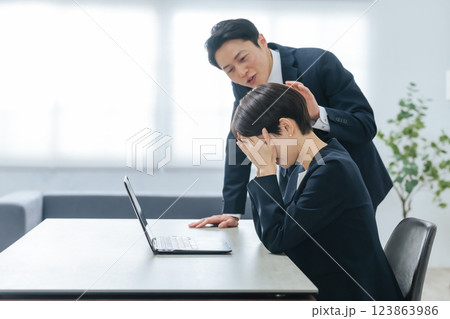 落ち込む女性ビジネスパーソンを慰める男性ビジネスパーソン 落ち込む女性ビジネスパーソンを慰める男性ビジネスパーソン 123863986
