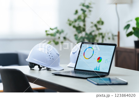 オフィスに置かれたノートパソコンとヘルメット 123864020