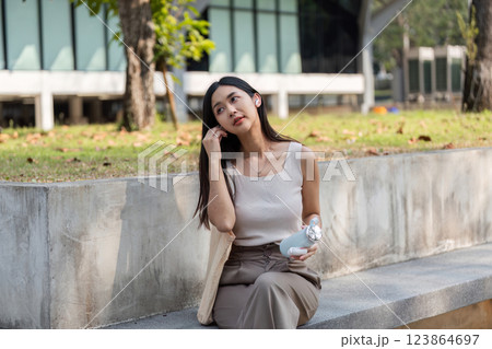 Sustainable lifestyle. Young woman enjoying a reusable cup while sitting outdoors. Sustainable lifestyle. Young woman enjoying a reusable cup while sitting outdoors. 123864697