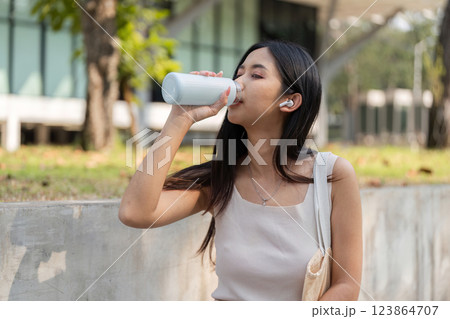 Sustainable lifestyle. Woman drinking from a reusable cup outdoors. Sustainable lifestyle. Woman drinking from a reusable cup outdoors. 123864707