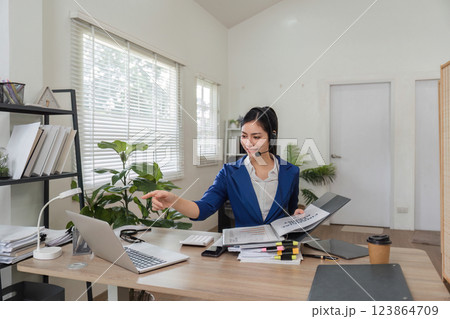 Remote work and communication. Woman on a video call managing business tasks in a modern office. Remote work and communication. Woman on a video call managing business tasks in a modern office. 123864709