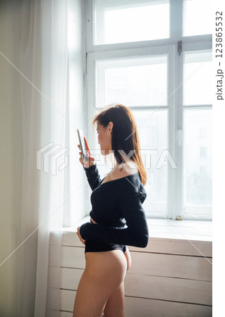 Beautiful woman in lingerie taking photos with smartphone 123865532