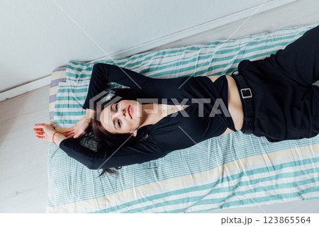 Beautiful fashionable brunette woman lying on sleeping mattress Beautiful fashionable brunette woman lying on sleeping mattress 123865564