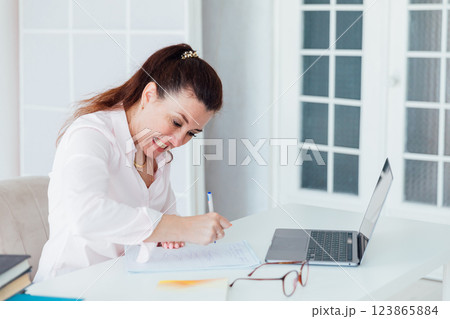woman at desk with laptop nervous writing online woman at desk with laptop nervous writing online 123865884
