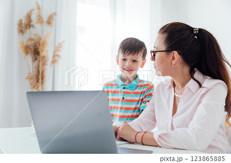 Female teacher teaching boy at desk with laptop 123865885