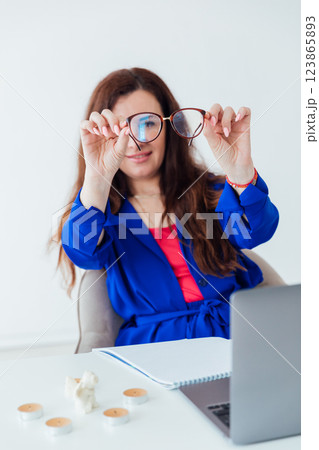 Business woman looking with glasses at office desk Business woman looking with glasses at office desk 123865893