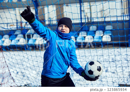 Victorious goalkeeper holding ball, signaling successful save, expressing joy and confidence in soccer performance. Celebration of Achievement. 123865934