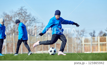 Competitive intensity. Two young players in motion, fiercely competing for ball control during soccer practice, honing technical skills. Competitive intensity. Two young players in motion, fiercely competing for ball control during soccer practice, honing technical skills. 123865942