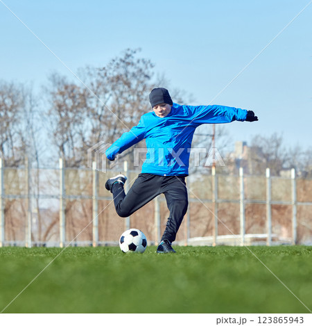 Precision shooting practice. Young footballer executing strong kick with focused technique on stadium field, mastering goal accuracy. Precision shooting practice. Young footballer executing strong kick with focused technique on stadium field, mastering goal accuracy. 123865943