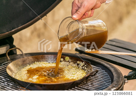 The chef prepares a traditional seafood paella on the grill. Traditional spanish dish. The chef prepares a traditional seafood paella on the grill. Traditional spanish dish. 123866081