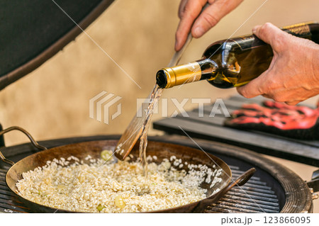 The chef prepares a traditional seafood paella on the grill. Traditional spanish dish. 123866095