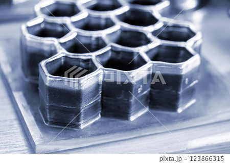 Objects printed with a 3D printer from a filament of molten metal on a table. 123866315