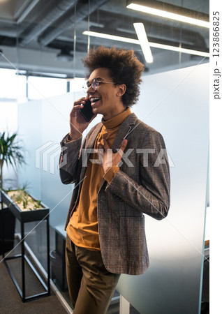 Good-looking young man wit a phone in hands in the office 123866825