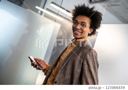 Confident curly-haired young businessman in the office 123866839